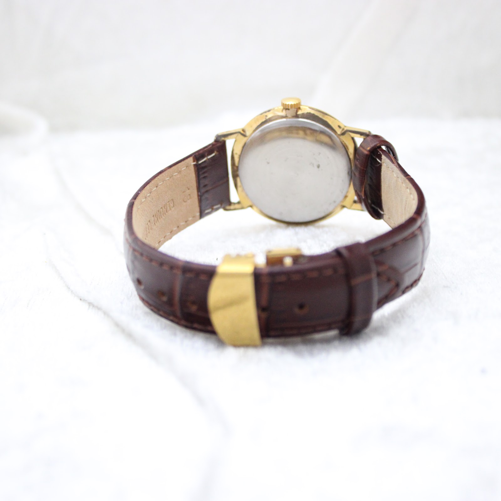 Back view of the Rotary watch, showing the stainless steel case back and the brown genuine leather strap.