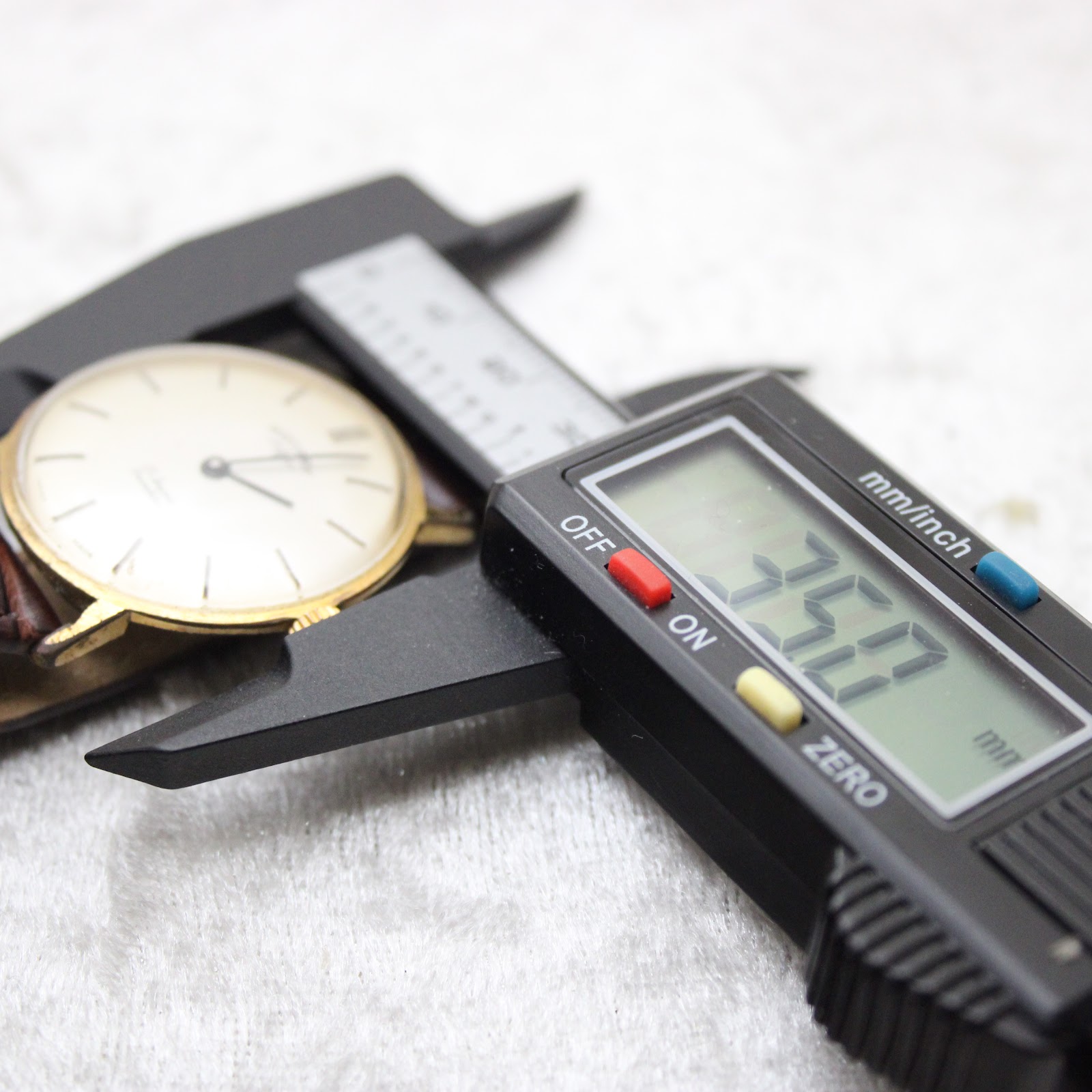 Close-up showing a digital caliper measuring the watch case diameter at precisely 35.0 mm.