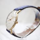 Angled side view of the gold-plated Sekonda watch, showing the crown and case profile.