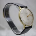 Second three-quarter view of the Mainstay watch on a clear stand, showing the classic dress watch design.
