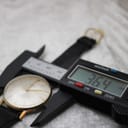 Close-up of a digital caliper measuring the watch width including the crown at 36.4mm.