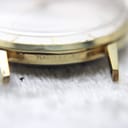 Macro shot of the watch case side, showing the "Plaqué G10" gold plating mark and some wear on the lug.