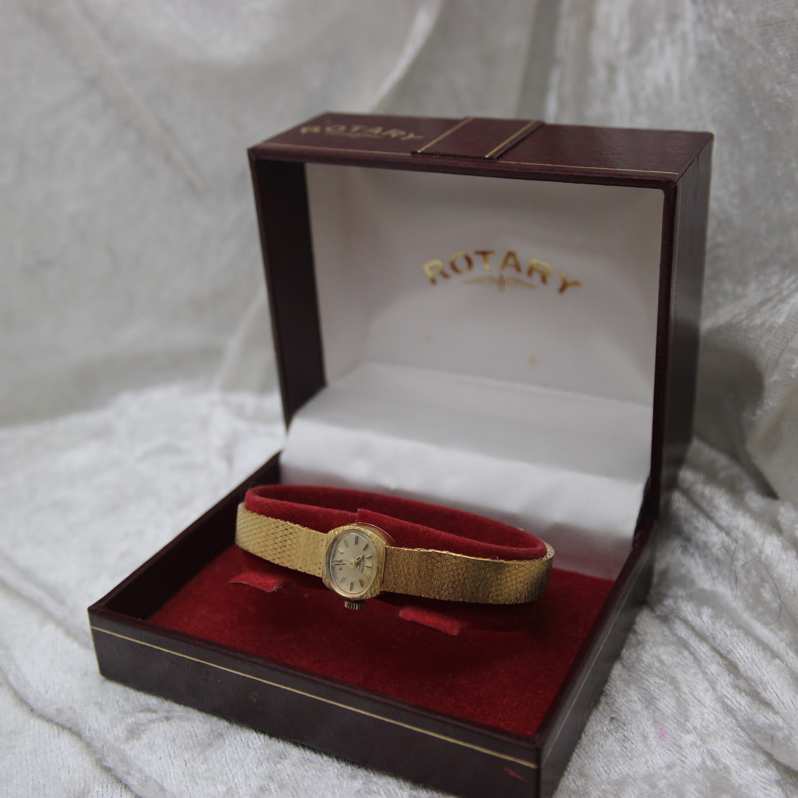 The Rotary watch nestled inside its original red presentation box with gold branding.