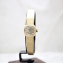 Slightly angled front-left view of the gold-tone Rotary watch on a black stand.