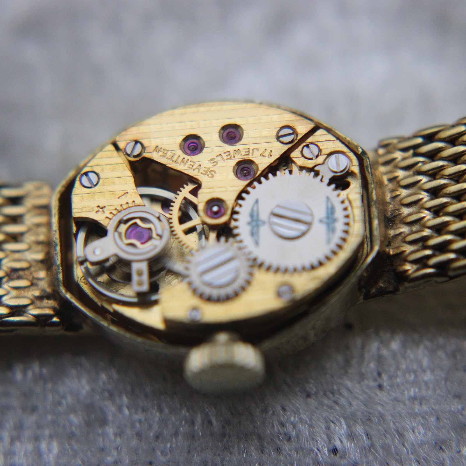 Close-up macro view of the intricate Swiss manual wind movement with visible jewels and gears.