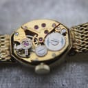 Close-up macro view of the intricate Swiss manual wind movement with visible jewels and gears.