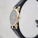 Side profile view of the gold-plated Gucci watch showing the signed crown.
