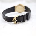 Close-up of the original black textured leather strap and the Gucci-signed buckle.