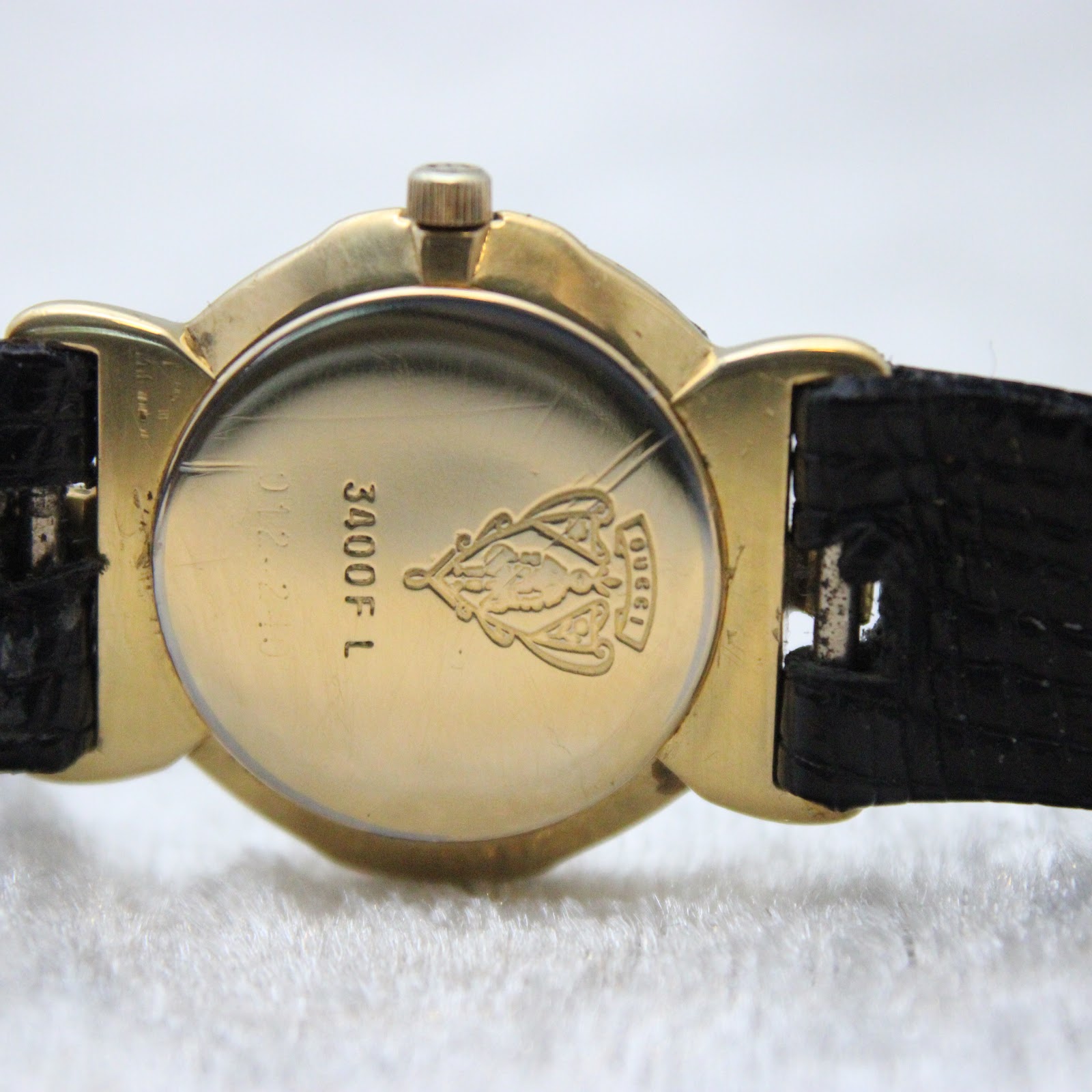 Detailed view of the gold-plated case back with Gucci logo, model number 3400F L, and serial.