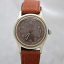 Front view of the vintage Roamer Breveté watch with its patinated brown dial and brown leather strap.