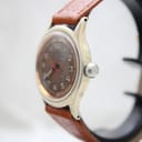 Side profile of the Roamer watch, showing the crown and the curvature of the gold-tone case.