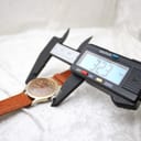 Digital caliper measuring the case diameter of the Roamer watch, showing a reading of 32.3 mm.