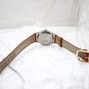 Underside of the brown leather strap, indicating 'GENUINE LEATHER' and the 18mm lug width.