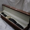 The Mondaine watch laid inside a wooden presentation box with a cream interior.