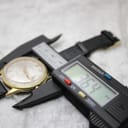 Digital caliper measuring the Aristocrat watch case, displaying a measurement of 36.4 mm.