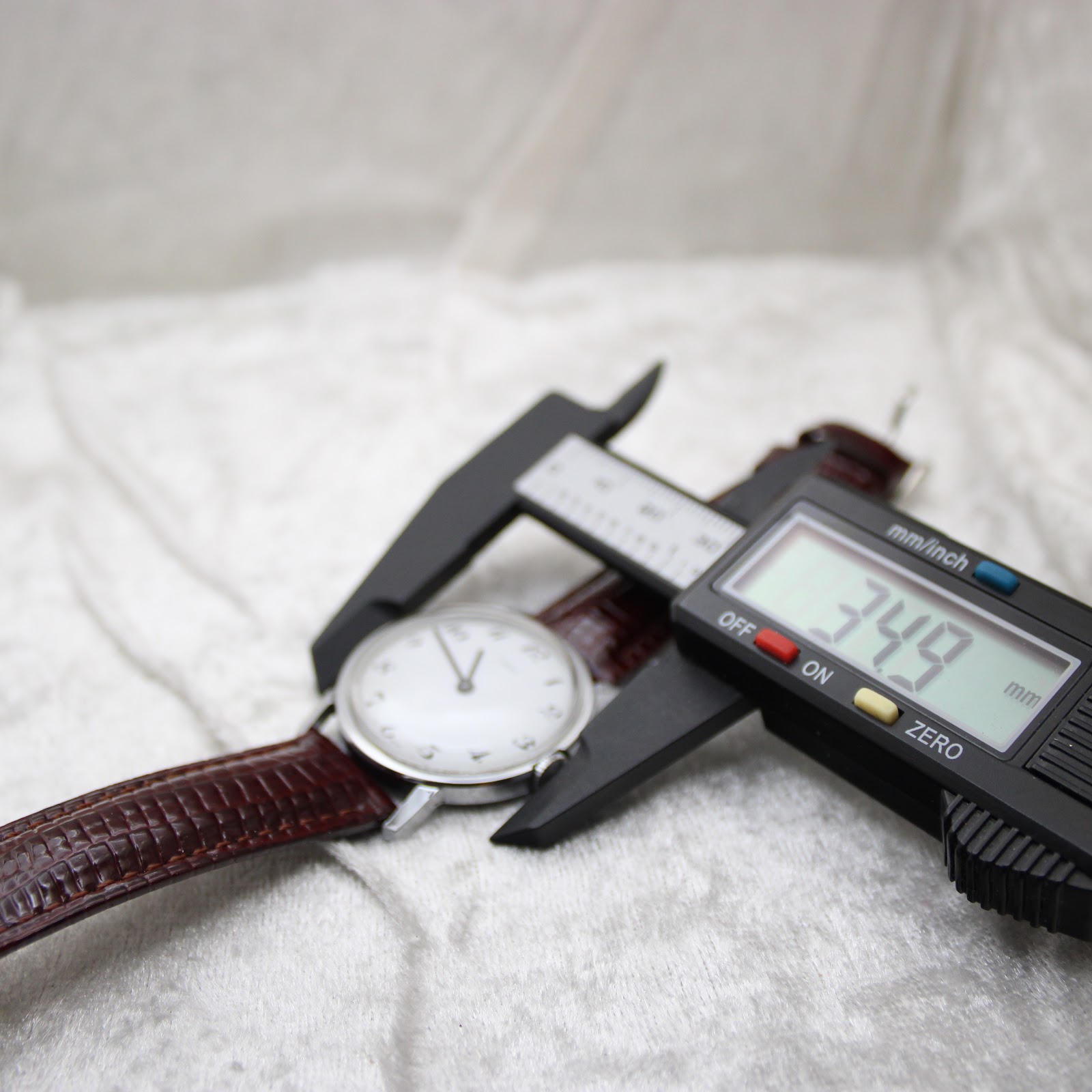 Digital caliper measuring the case diameter of the Timex watch, displaying 34.9 mm.