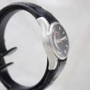 Other side view of the Mondaine watch showing the brushed stainless steel case and black leather strap