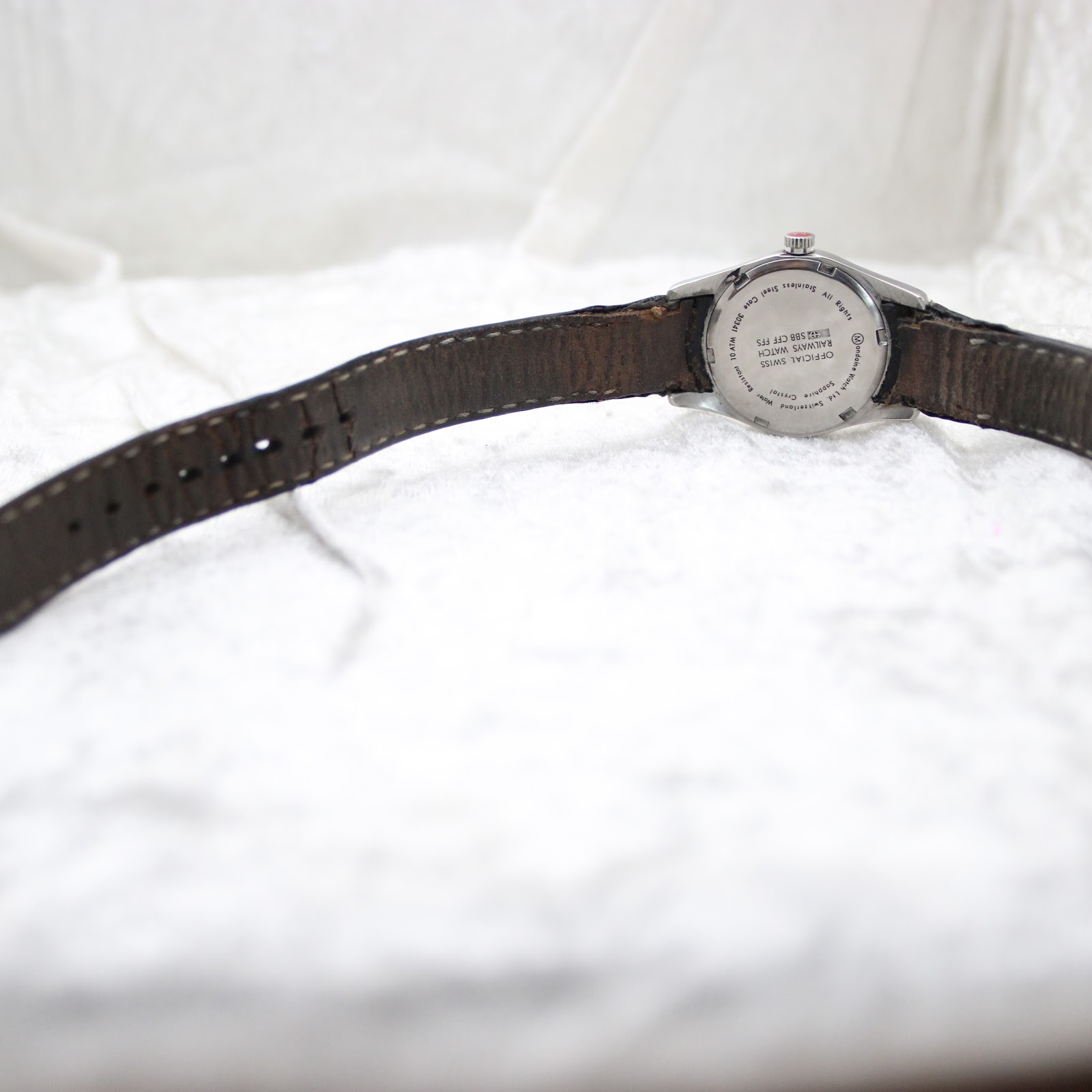 Back view of the Mondaine watch showing the case back and the full length of the black leather strap