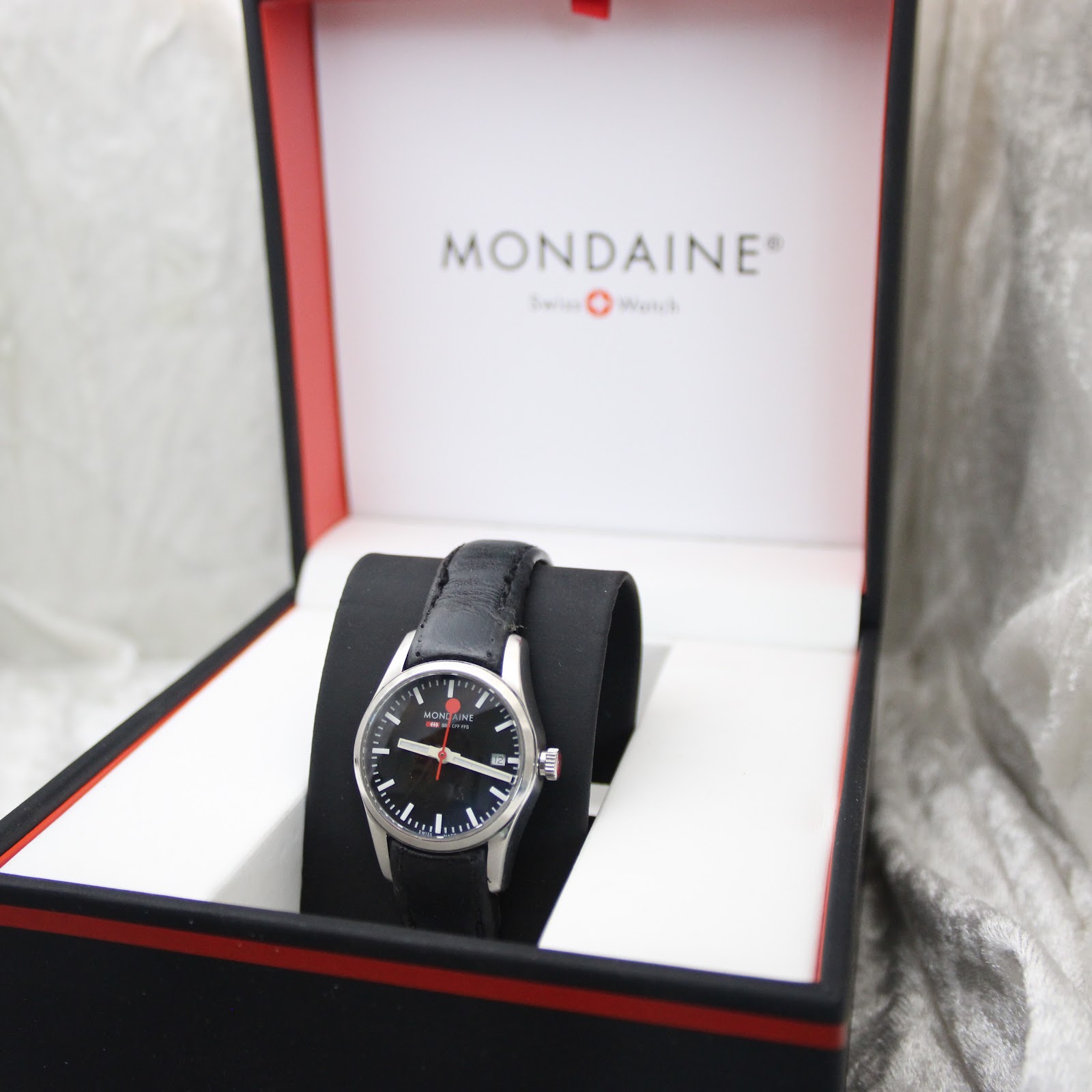 The Mondaine watch presented in its original black and red Mondaine box