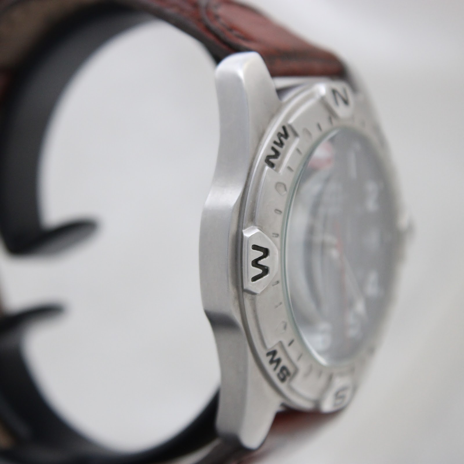 Opposite side view of the watch case highlighting the compass bezel markings and robust construction.