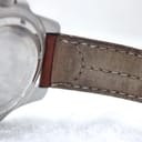 Close-up of the brown leather strap near the lug, showing stitching and a faint embossed logo.