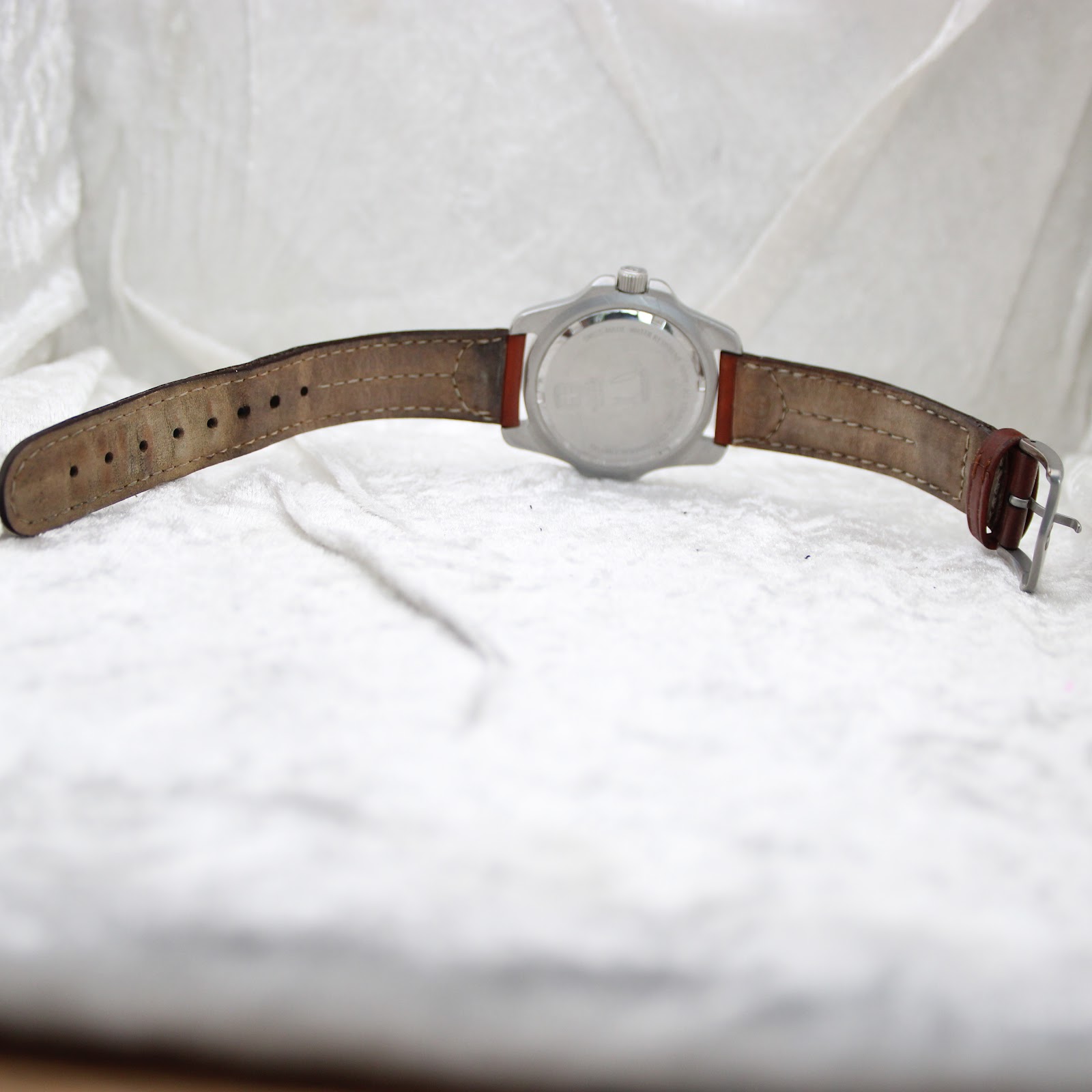 Full view of the watch from the back, displaying the worn brown leather strap and case back.