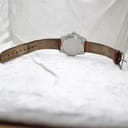 Full view of the watch from the back, displaying the worn brown leather strap and case back.