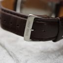 Close-up of the stainless steel buckle signed "SWISS ARMY" on the brown leather strap.