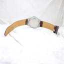 Rear view of the watch showing the stainless steel caseback and the brown leather strap laid open.