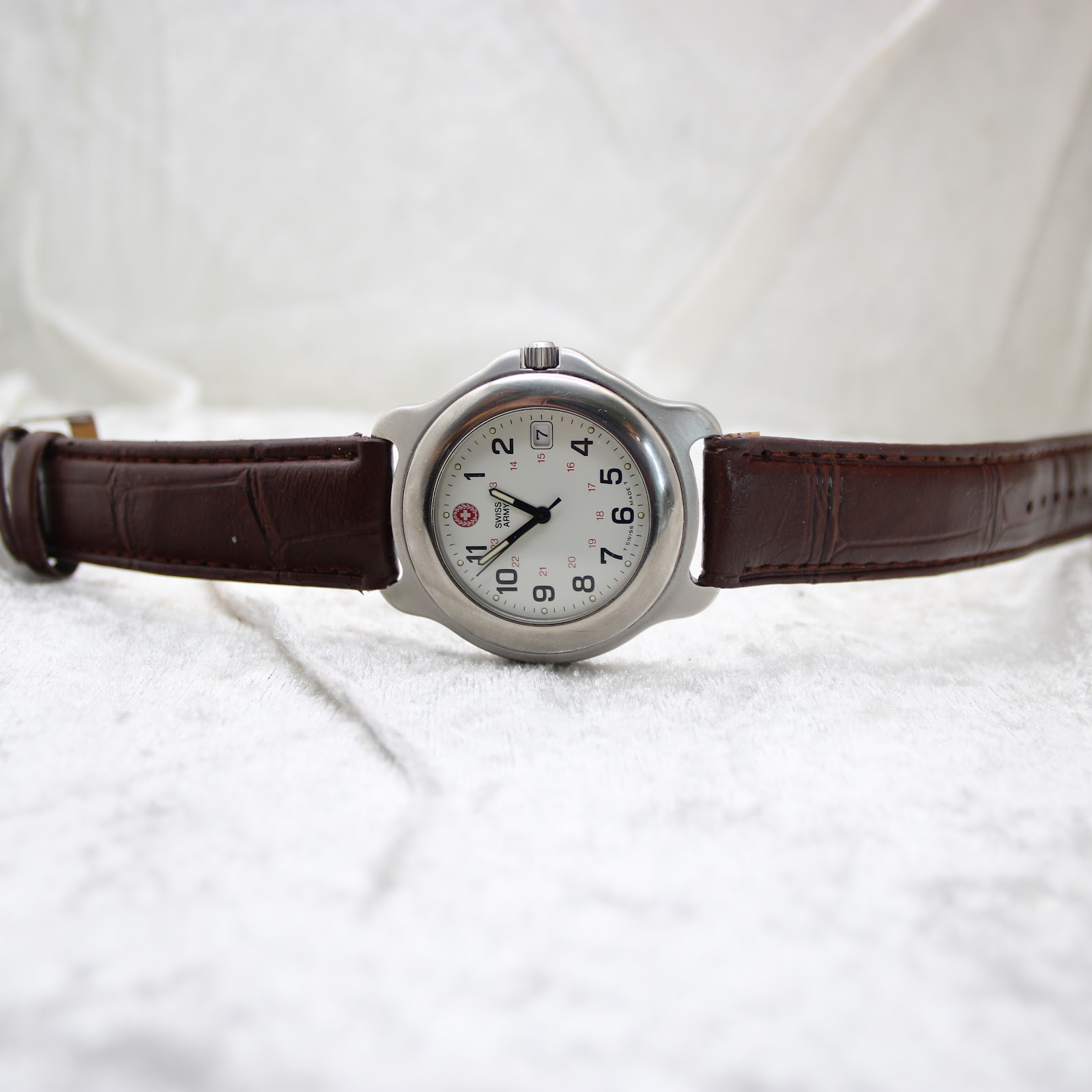 Full front view of the Swiss Army quartz watch, showing the white dial and brown leather strap on a light background.