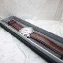 The Swiss Army watch with its brown leather strap displayed in a long, grey and black presentation box.