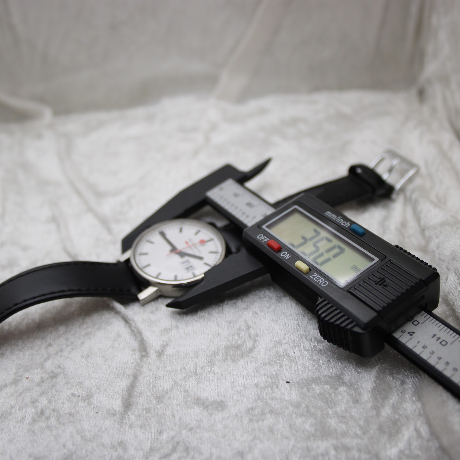 A digital caliper measuring the watch's case diameter, with the display clearly showing a precise measurement of 35.0 mm.