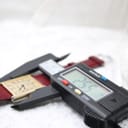 Digital caliper measuring the width of the Corteal watch case at 25.5mm, with the watch resting on a white surface.