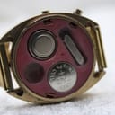 Close-up of the Chronex watch's open case back, showing two round battery compartments with 'LR43' cell visible, and other internal details.