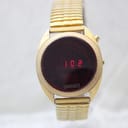 Front view of the Chronex LED watch displaying "1 0 2" in red, with 'CHRONEX' visible below the display, all within a gold-tone case and expansion bracelet.