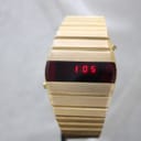 Front-on view of the gold-plated La Générale LED watch, with the red LED display brightly showing the time '1:05'.