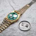 Back view of the La Générale watch with the stainless steel case back removed, revealing two batteries and the green electronic movement housing.