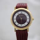 Front view of Burberrys of London 6000L gold-tone watch with burgundy dial and white Roman numerals.
