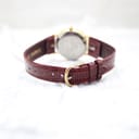Rear view of the Burberrys watch, showing the burgundy leather strap and gold-tone buckle.