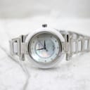 Front view of the Escada Lauren watch lying on a soft white fabric, displaying its polished and ceramic bracelet.
