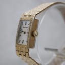 Angled side view of the Bulova watch, showing the gold-plated case, textured bracelet, and original signed crown.