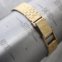 The textured gold-plated bracelet of the Bulova watch wrapped around a wrist sizing gauge, indicating a wrist circumference of 172mm.