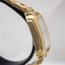Close-up of integrated gold-tone stainless steel bracelet and deployment clasp.