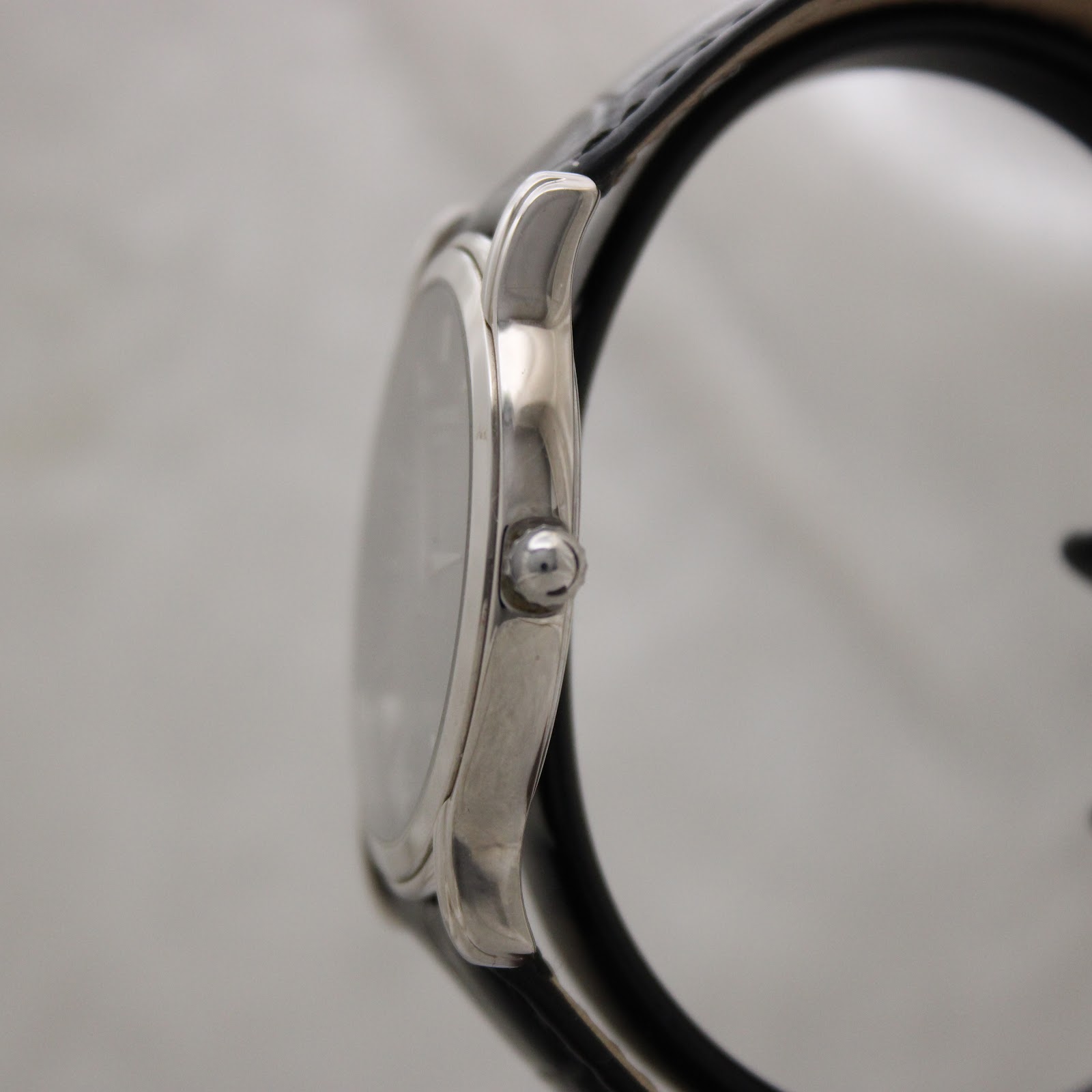 Side profile view of the polished stainless steel case and crown of the Raymond Weil 5571 watch.