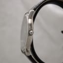 Side profile view of the polished stainless steel case and crown of the Raymond Weil 5571 watch.