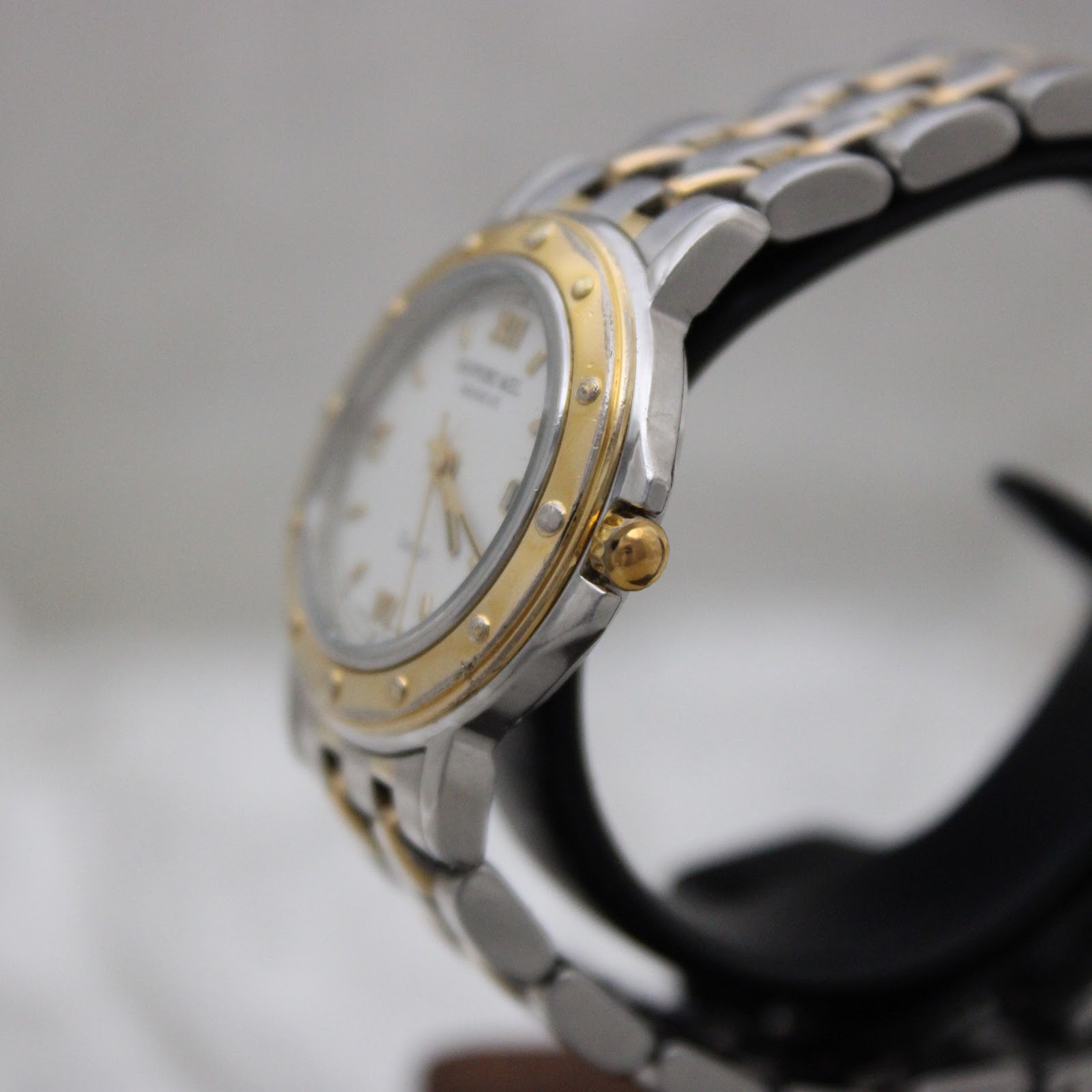 Side view of the Raymond Weil Tango watch, showing the gold-tone crown and riveted bezel.