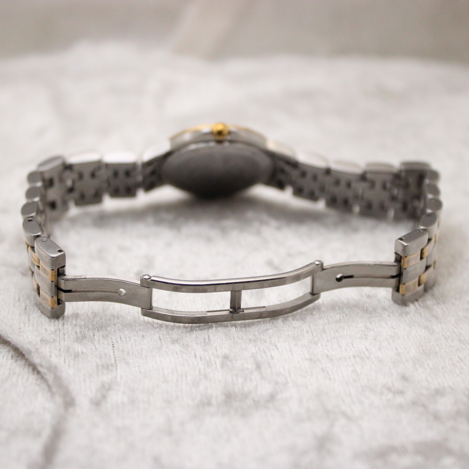 View of the open butterfly deployment clasp on the two-tone stainless steel bracelet.