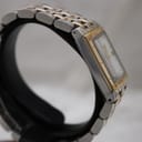 Left side profile view of the Raymond Weil Tango watch on a display stand, highlighting the rectangular stainless steel case and bi-tone bracelet.