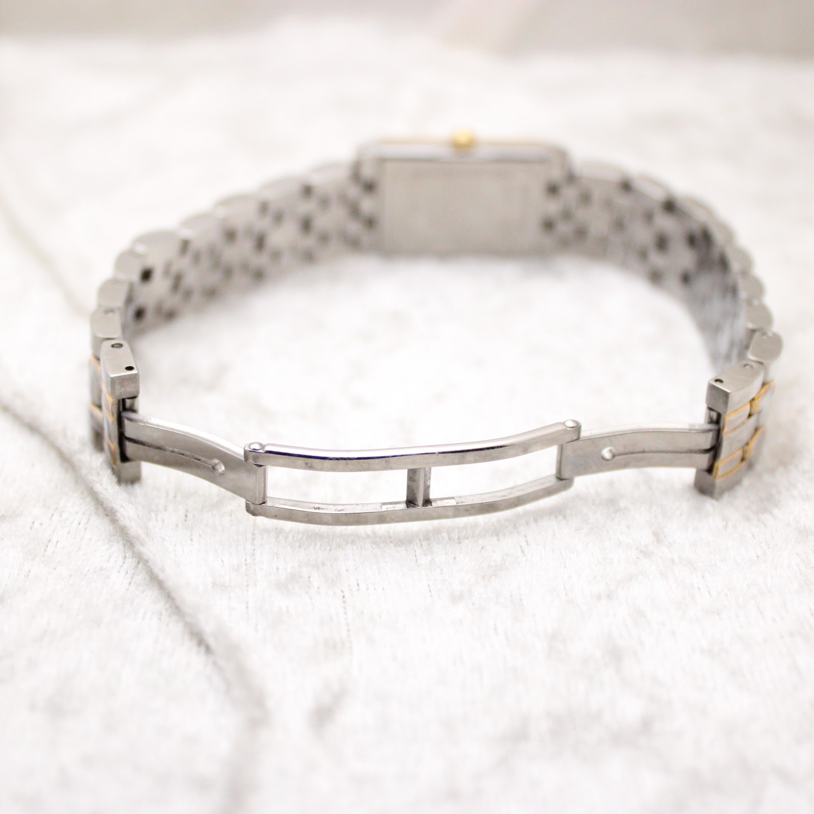 View of the opened bi-tone stainless steel bracelet clasp, showing the internal mechanism and links.