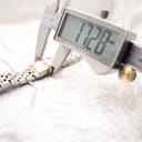 Close-up of a digital caliper measuring the watch case width at 17.28mm.